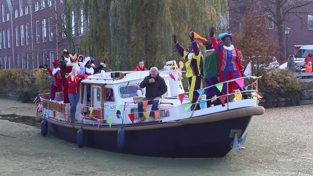 Sinterklaas op een boot met Pieten bij de intocht in haven Wassenaar